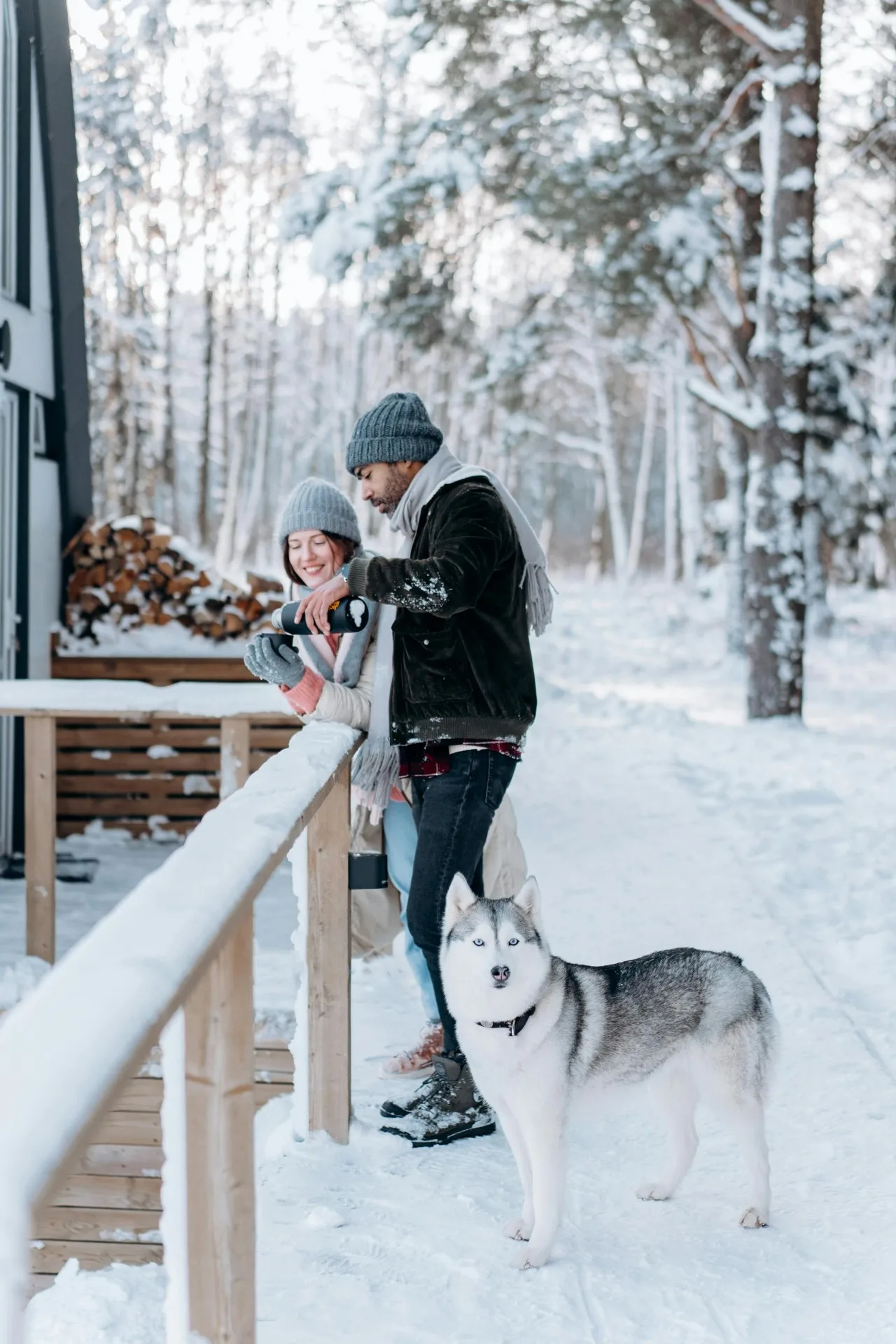 Casal com husky na neve do inverno canadense